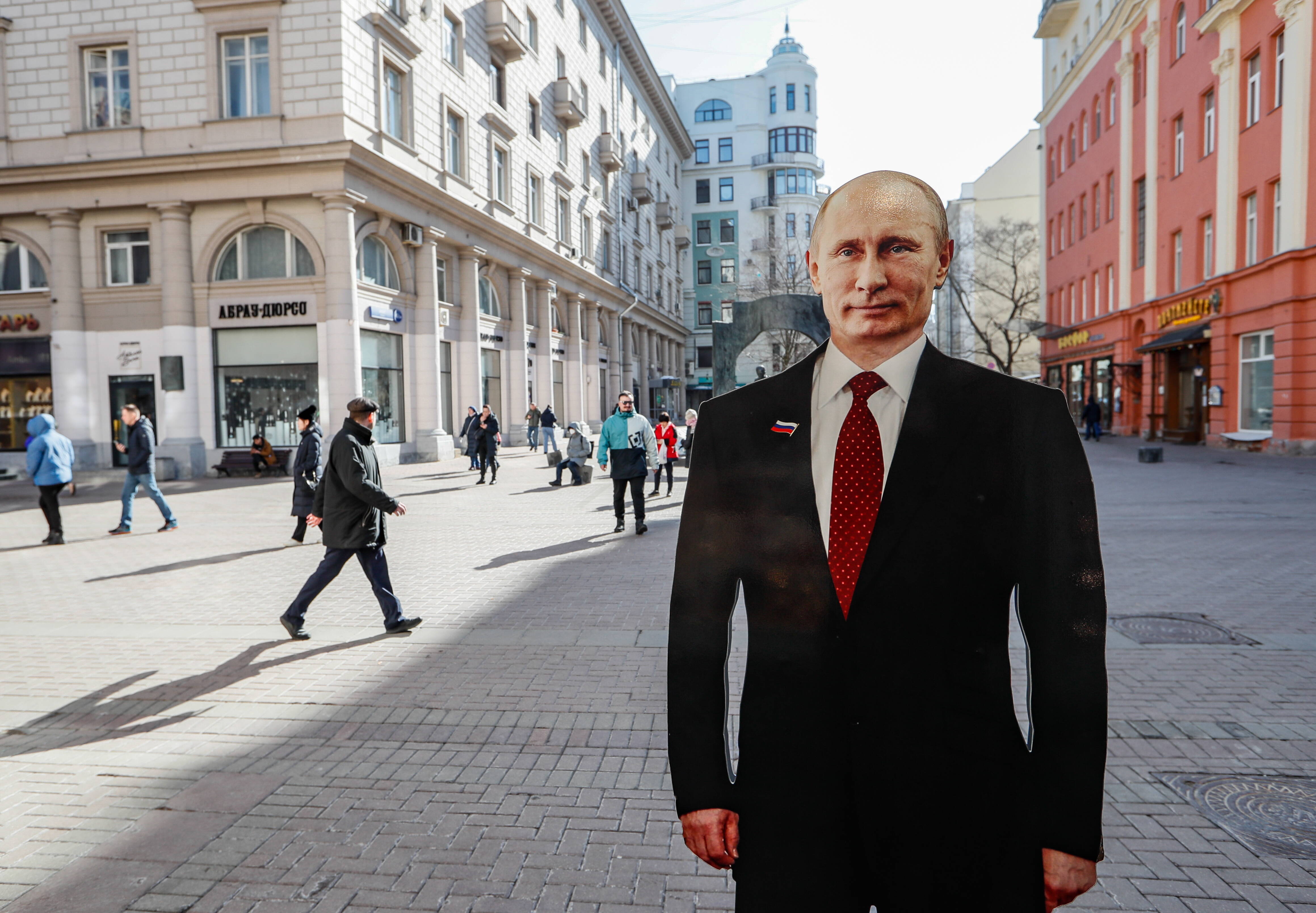  Люди проходять повз картонний макет президента Росії Володимира Путіна на вулиці в Москві. Fot. PAP/EPA/YURI KOCHETKOV
