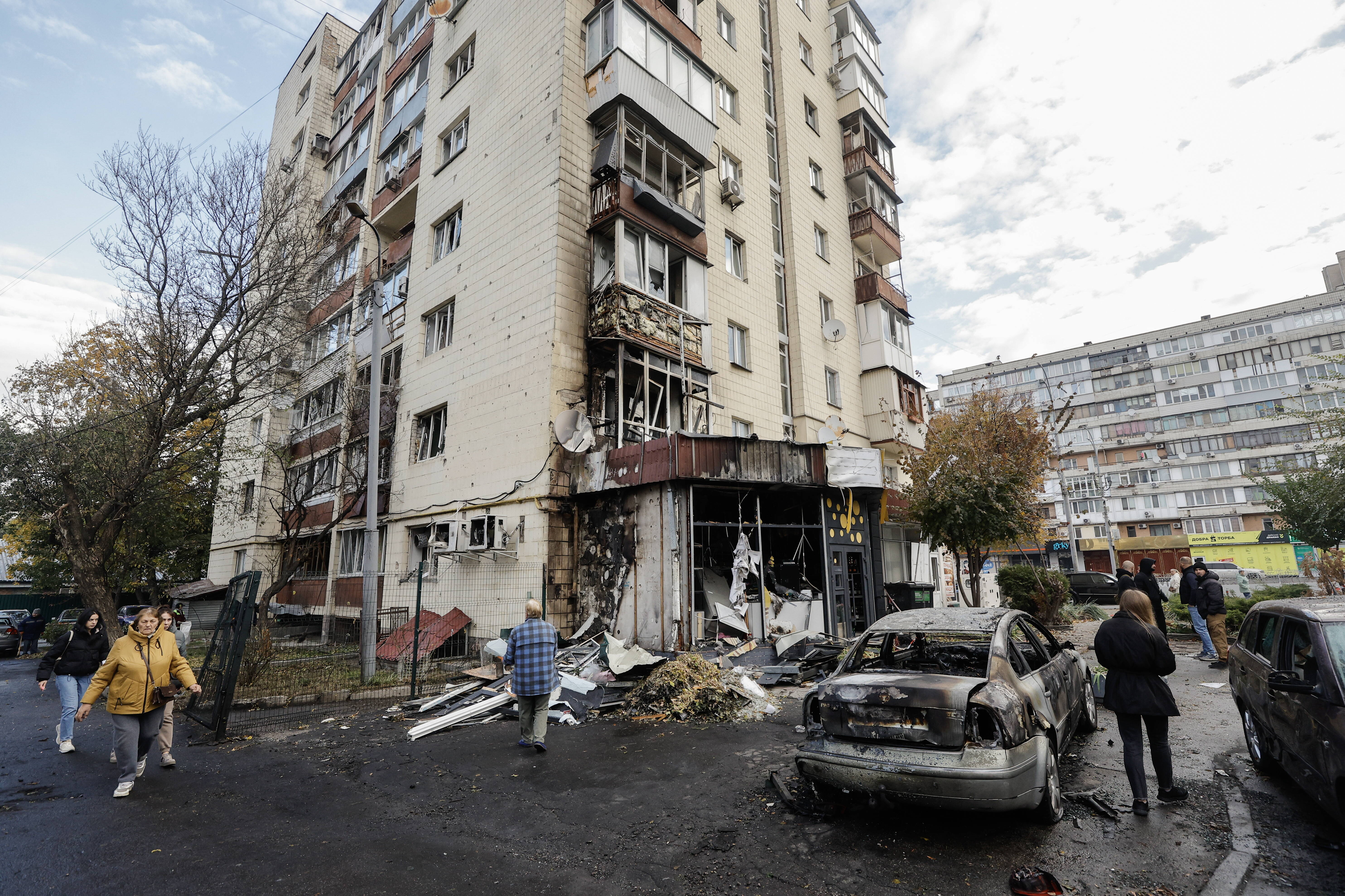 Люди оглядають пошкодження після нічної атаки безпілотника на багатоповерховий будинок у Києві, Україна, 29 жовтня 2024 року. Fot. PAP/EPA/SERGEY DOLZHENKO 