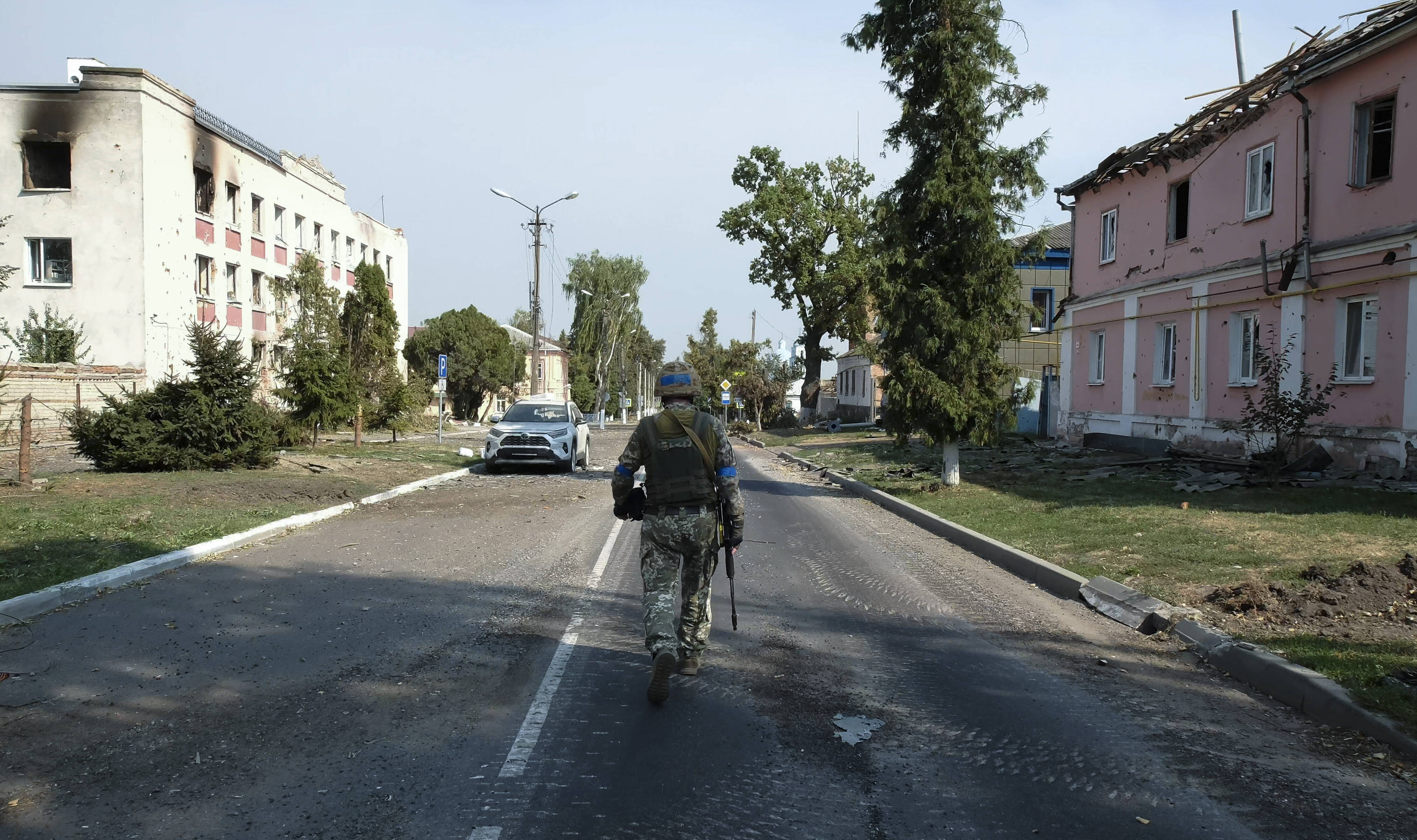 Український військовий проходить біля пошкоджених будівель у центрі міста Суджа на підконтрольній Україні території Курської області Росії, 21 серпня 2024 року. Fot. PAP/EPA/STRINGER