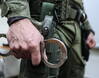 Funkcjonariusz CBŚP trzymający kajdanki. Zdjęcie ilustracyjne. Fot. PAP/Leszek Szymański
