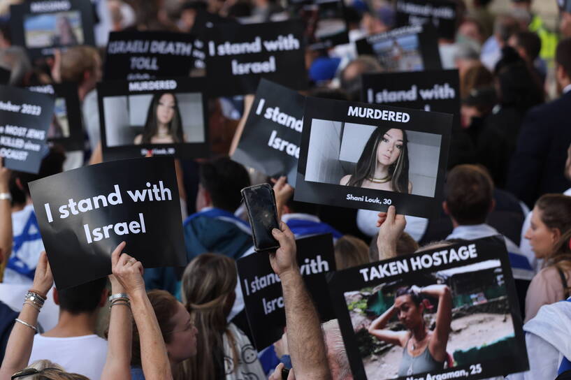 Protestujący Izraelczycy trzymający banery ze zdjęciami osób zamordowanych i porwanych do niewoli, fot. PAP/EPA/NEIL HALL
