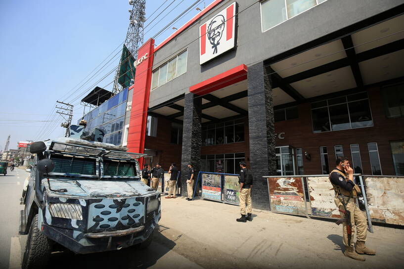 Pakistańska policja przed zniszczonym lokalem KFC, fot. PAP/EPA/ARSHAD ARBAB