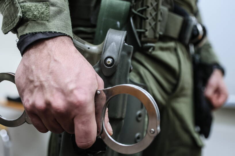 Funkcjonariusz CBŚP trzymający kajdanki. Zdjęcie ilustracyjne. Fot. PAP/Leszek Szymański