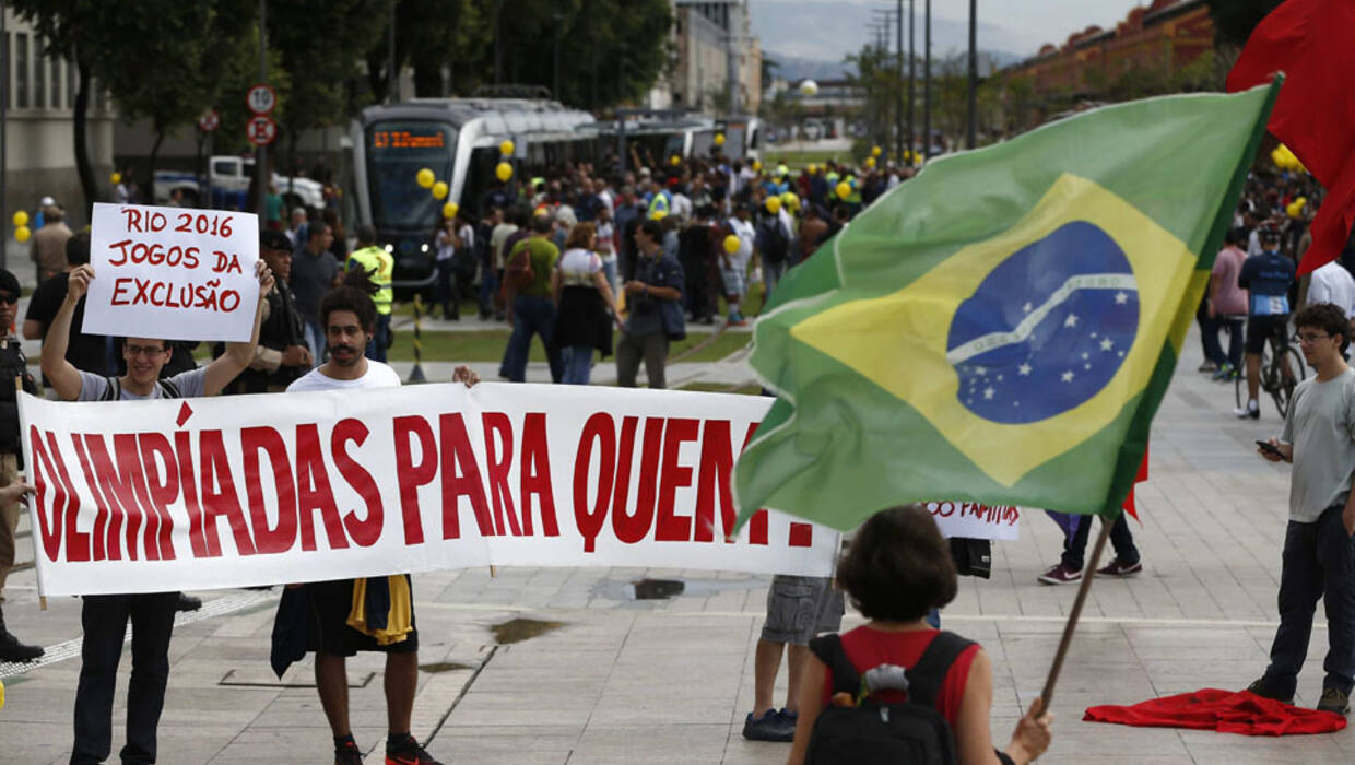 epa05347624 A group of people protesting with banners that read 'Olympics for whom' as an electric tramway that will travel through several streets of the city center replacing numerous bus lines and was conceived as one of the main Olympic legacies begins operating in Rio de Janeiro, Brazil, on 05 June 2016. EPA/Marcelo Sayăo Dostawca: PAP/EPA. Archiwum PAP/EPA © 2016 / Marcelo Sayăo