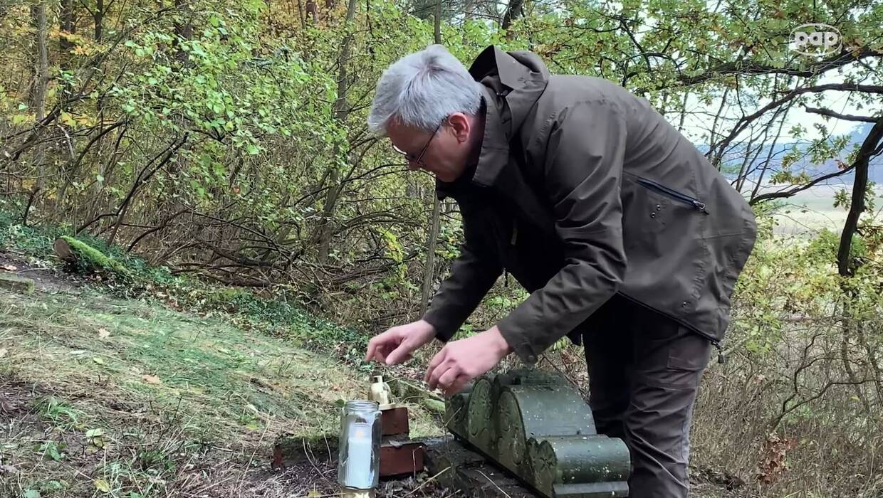 Leśnik zapalający znicz. Fot. Lech Muszyński