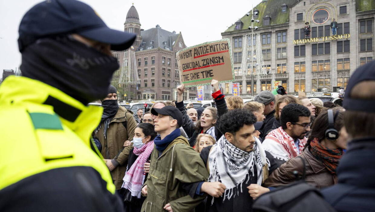 Pro-palestyńscy protestujący twarzą w twarz z holenderską policją na placu Dam w Amsterdamie. EPA/Robin Van Lonkhuijsen