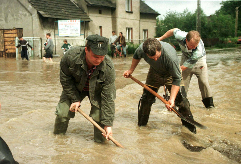 Powódź w Lubomii. N/z: udrażnianie przepływu potokowi rwącemu ulicami miasta. Fot. PAP/CAf - Romek Koszowski 