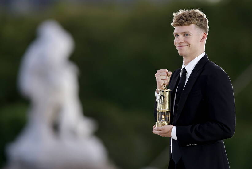 Francuski pływak Leon Marchand niesie płomień olimpijski na ceremonii zamknięcia igrzysk olimpijskich w Paryżu, fot. PAP/EPA/Tolga Akmen /POOL