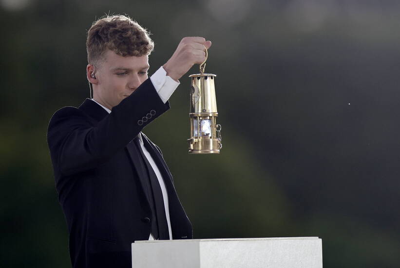 Francuski pływak Leon Marchand niesie płomień olimpijski na ceremonii zamknięcia igrzysk olimpijskich w Paryżu, fot. PAP/EPA/Tolga Akmen /POOL